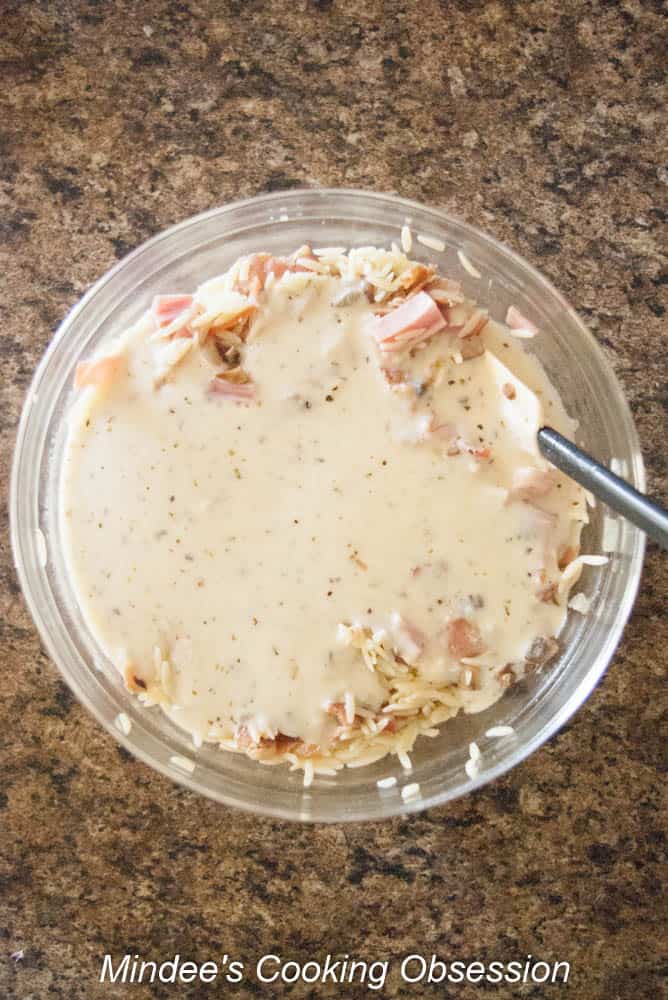 Cheese sauce poured over ingredients in the bowl.
