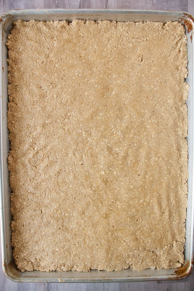 Oatmeal dough patted down into a baking sheet.