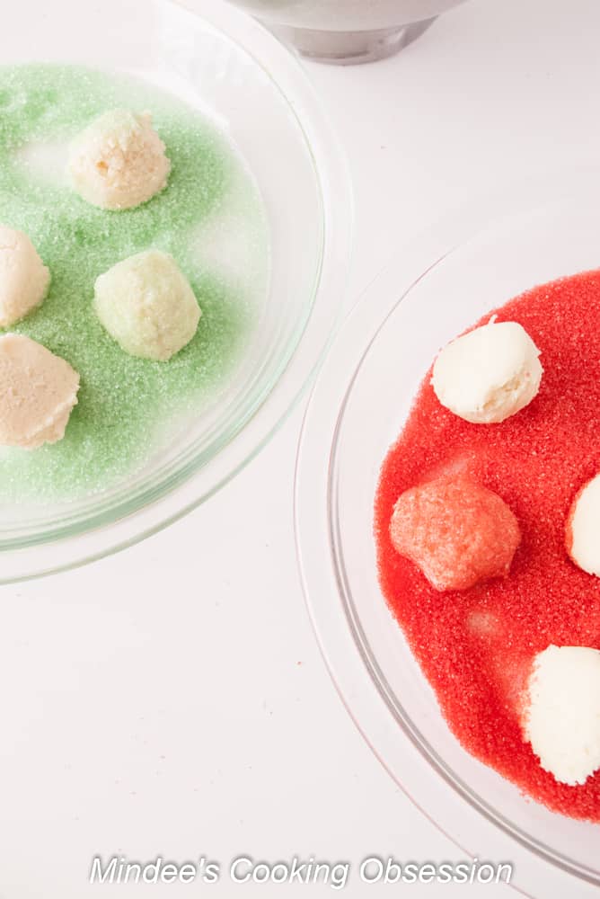Soft Drop Sugar Cookies being rolls through colored sugar sprinkles.