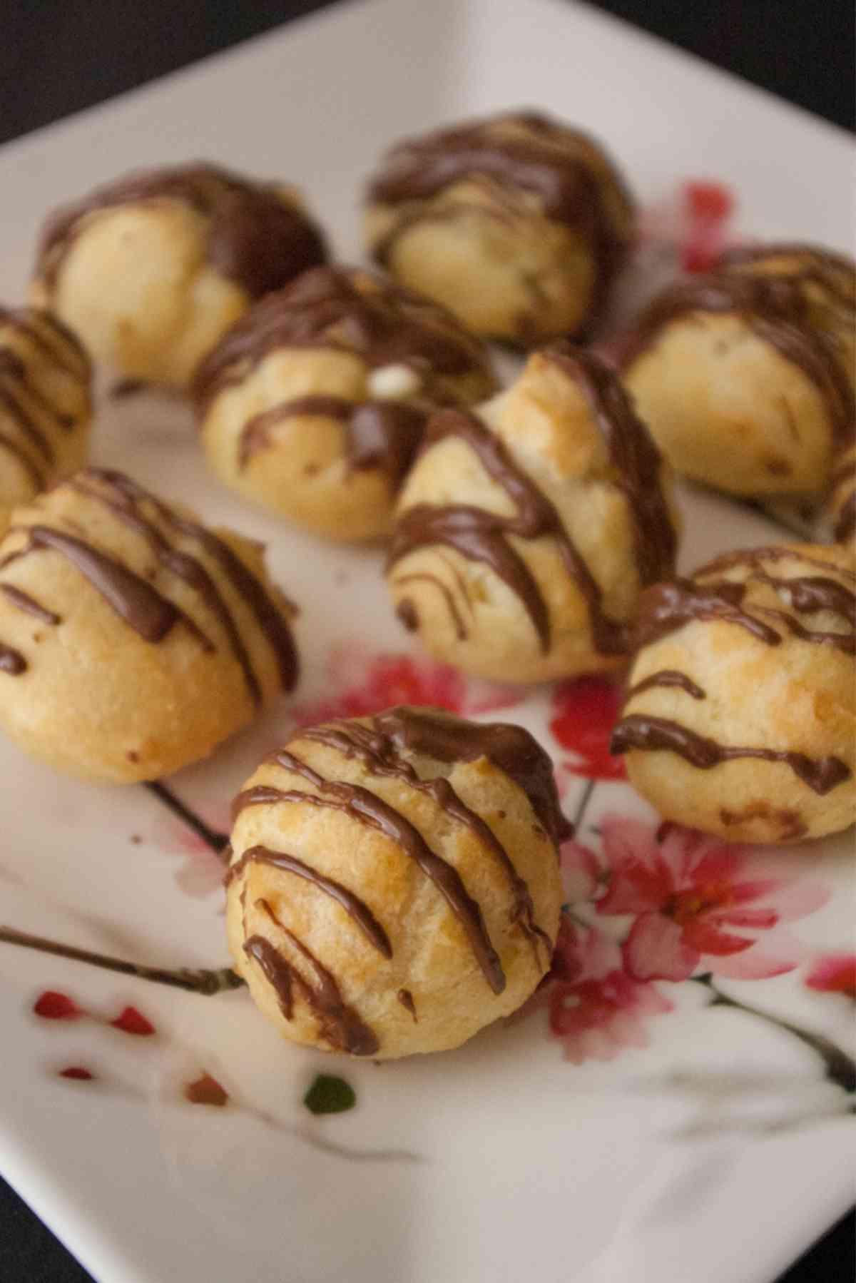 A fancy plate speckled with bite size cream puffs.