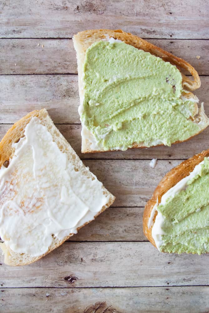 Sourdough halves spread with mayo and guacamole.