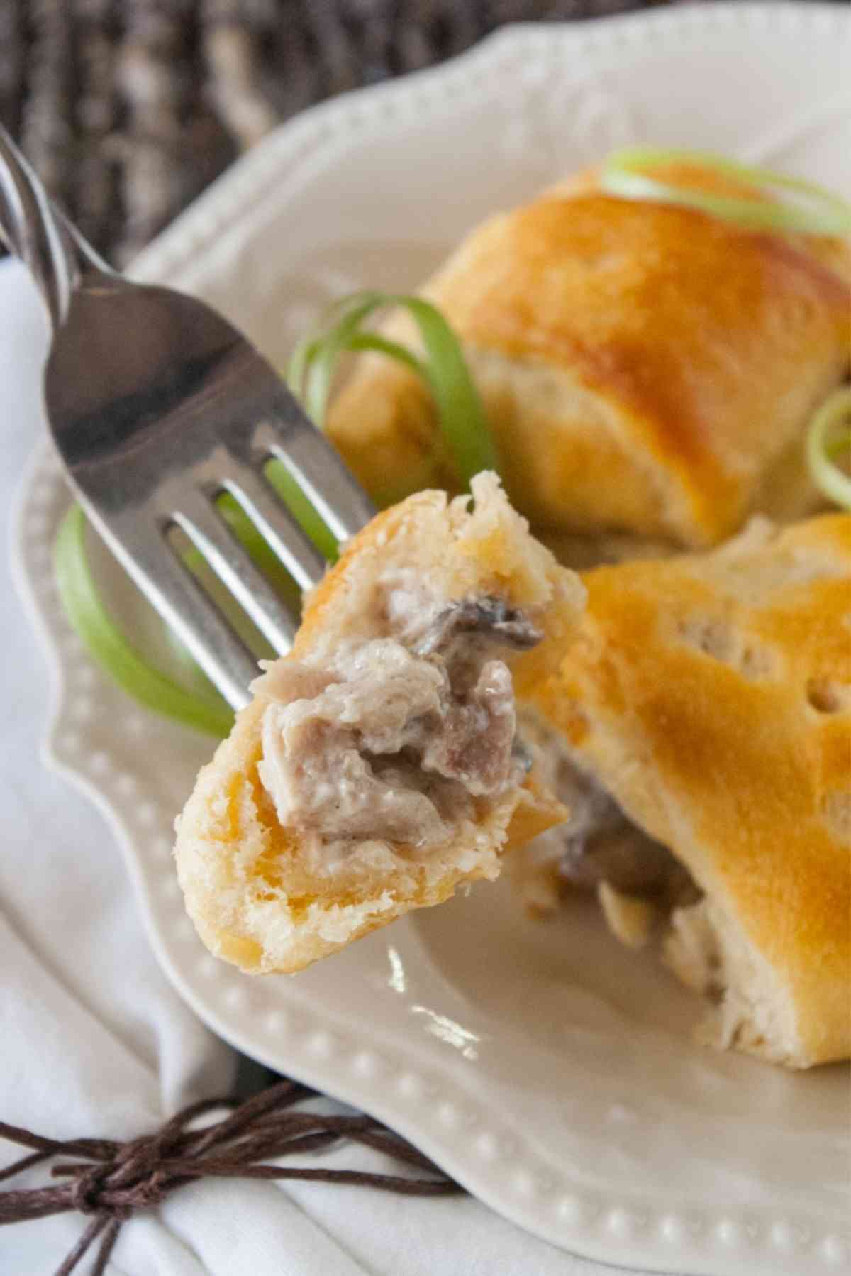 Bite of a turkey stuffed roll on the end of a fork.
