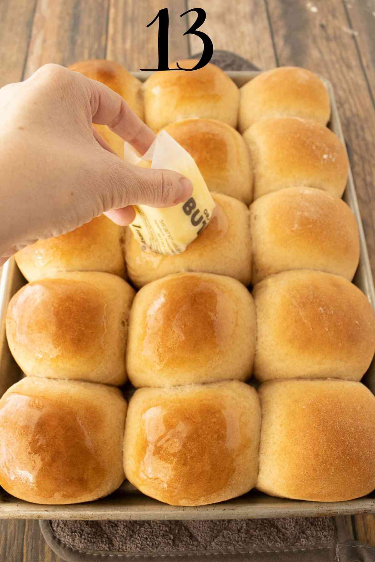 Butter cube being run over the top of the hot rolls.