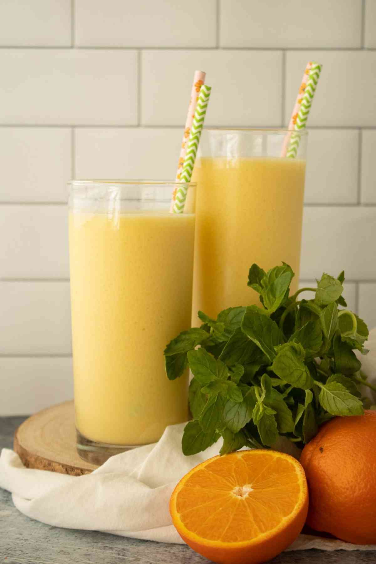 Two tall glasses of orange Julius with fun straws!
