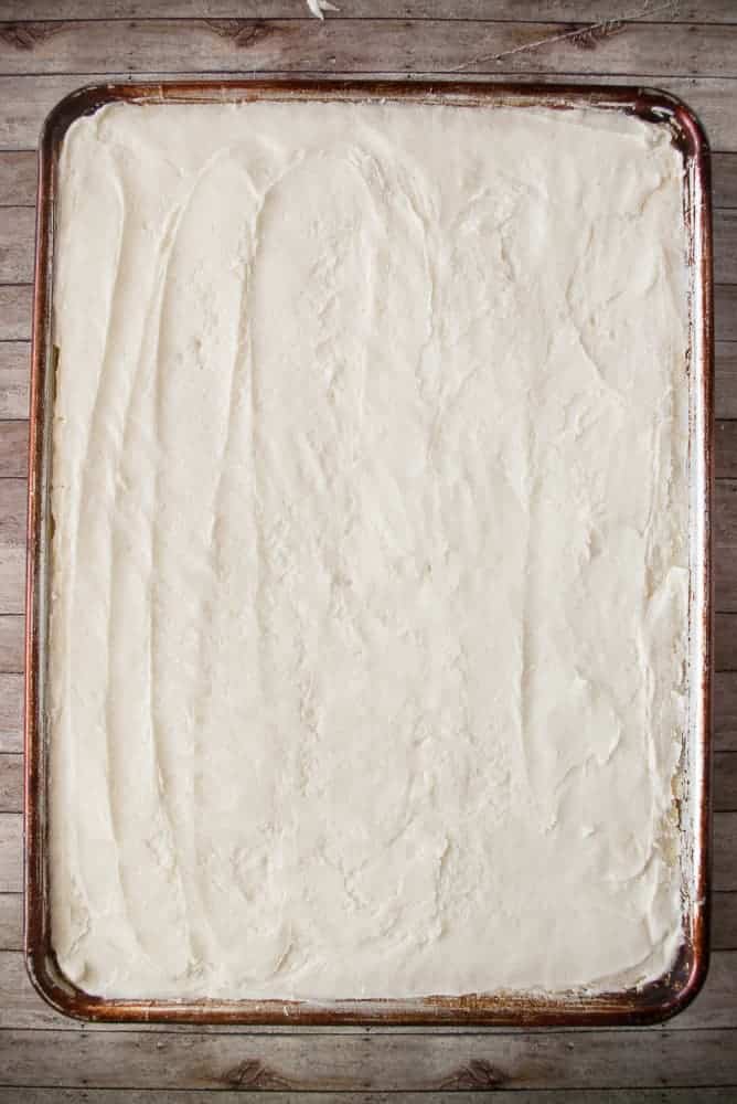 Hot lemon sheet cake frosted with warm frosting.