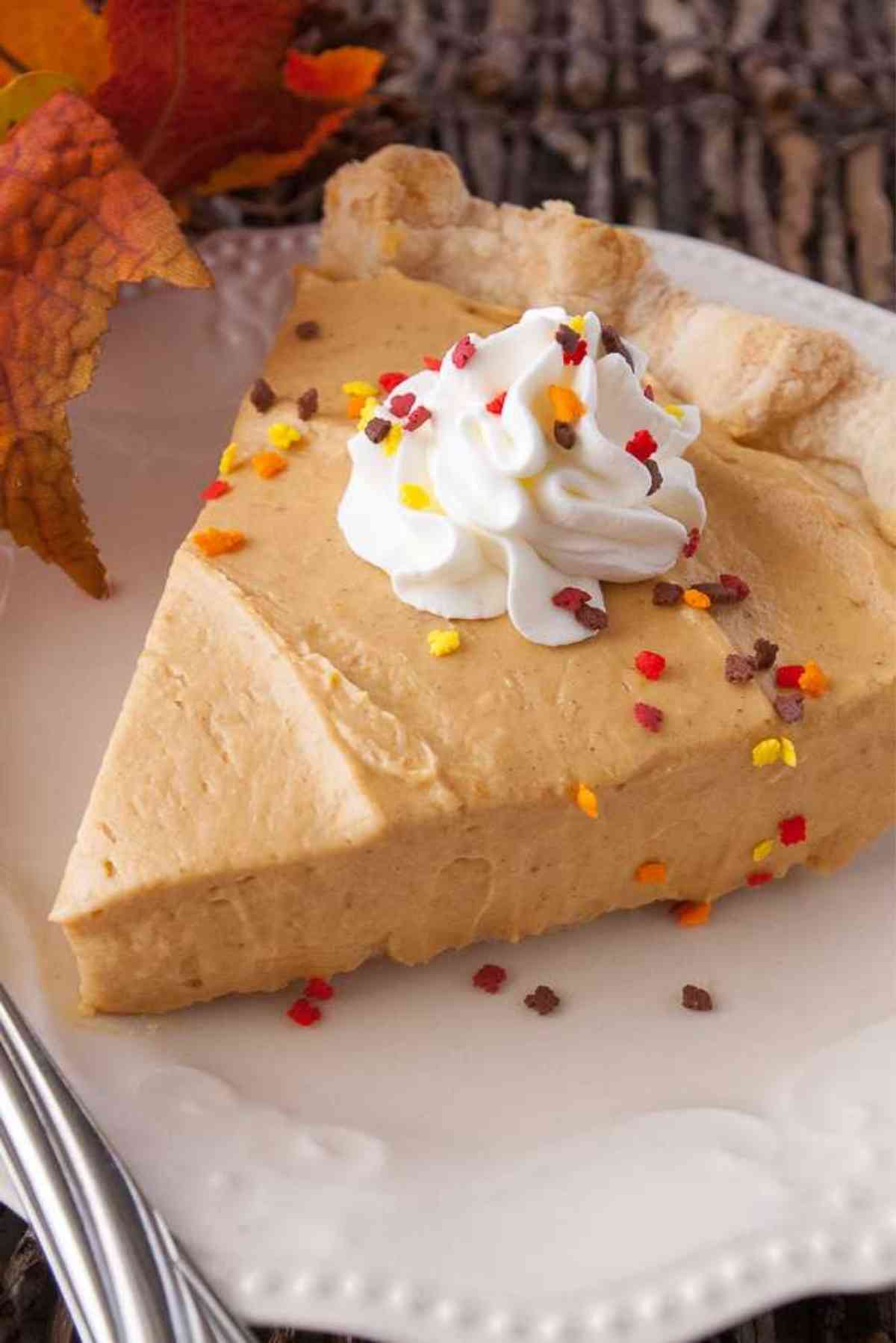 Slice of pumpkin cream pie topped with whipped cream.