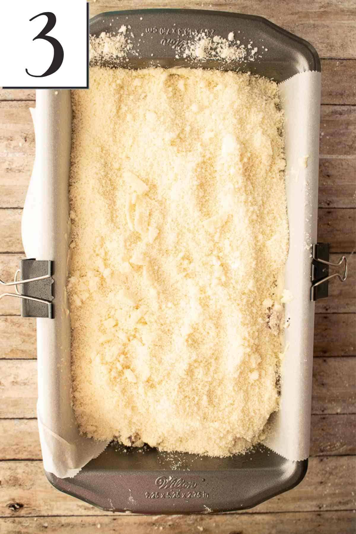 Batter spread into a loaf pan with topping evenly sprinkled across the top.