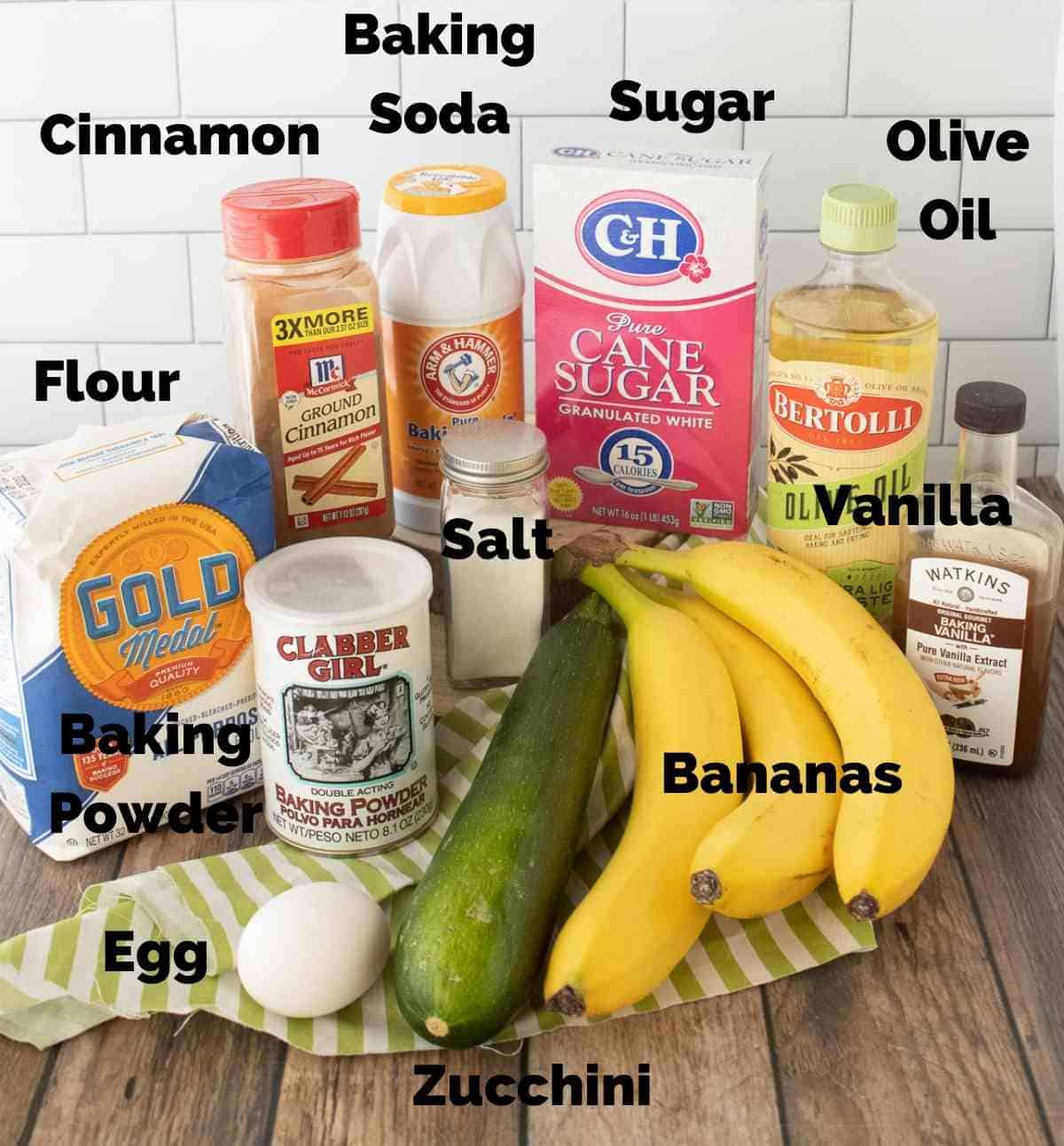 Ingredients needed for this recipe are Flour, Sugar, Cinnamon, Baking Soda, Baking Powder, Olive Oil, Salt, Vanilla, Bananas, Zucchini, and an Egg.