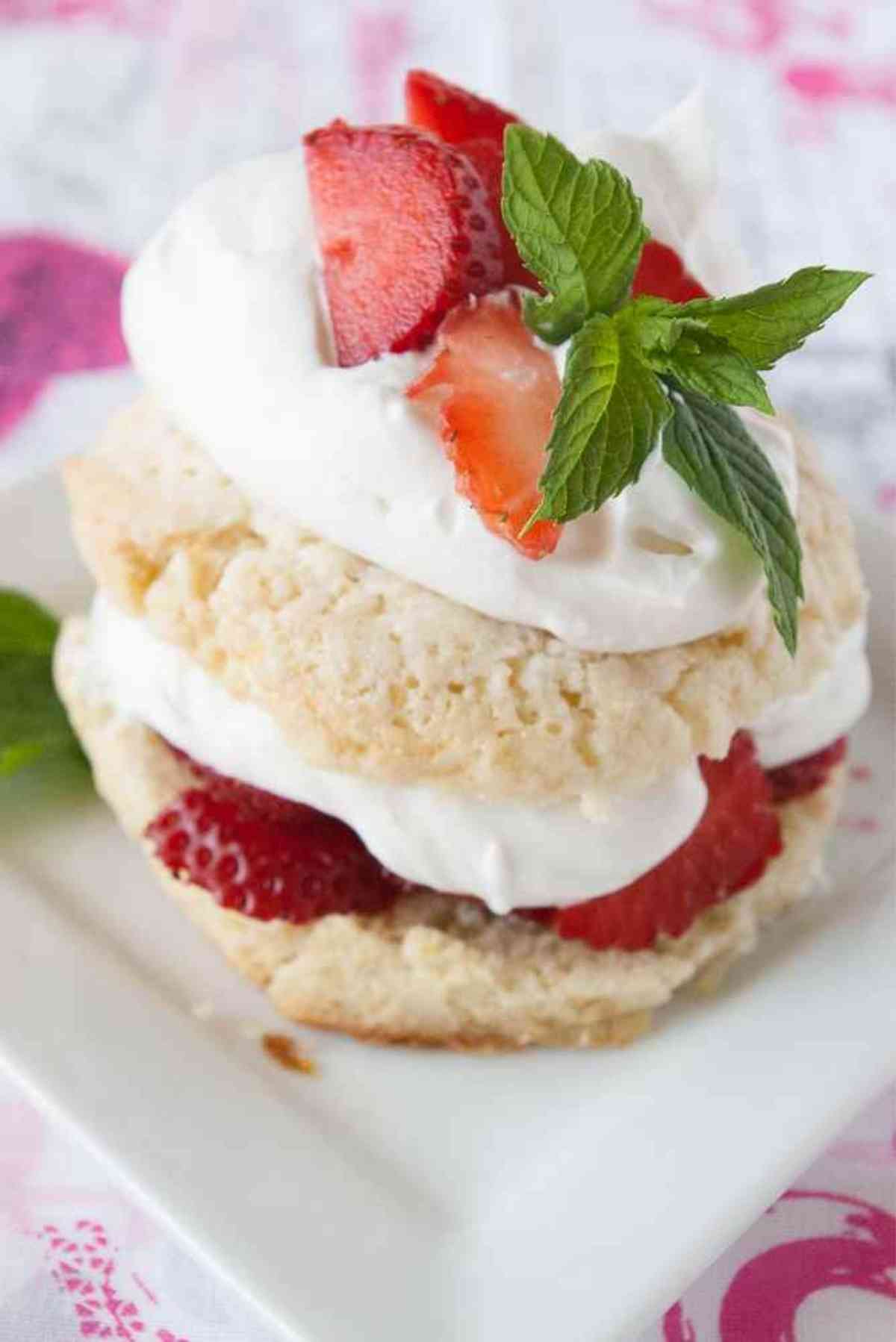 Strawberry shortcake garnished with mint and fresh strawberries.