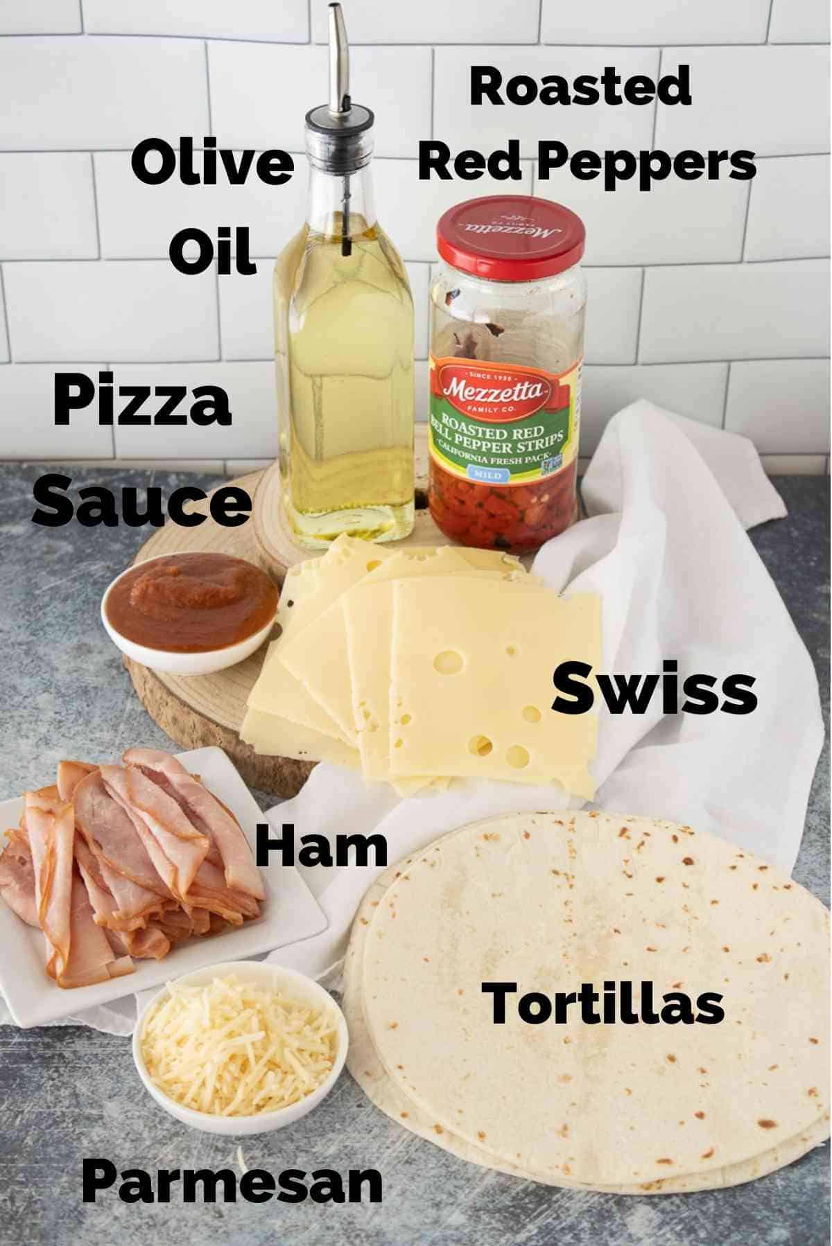 Tortillas, ham, swiss and other ingredients to make ham and cheese roll ups.