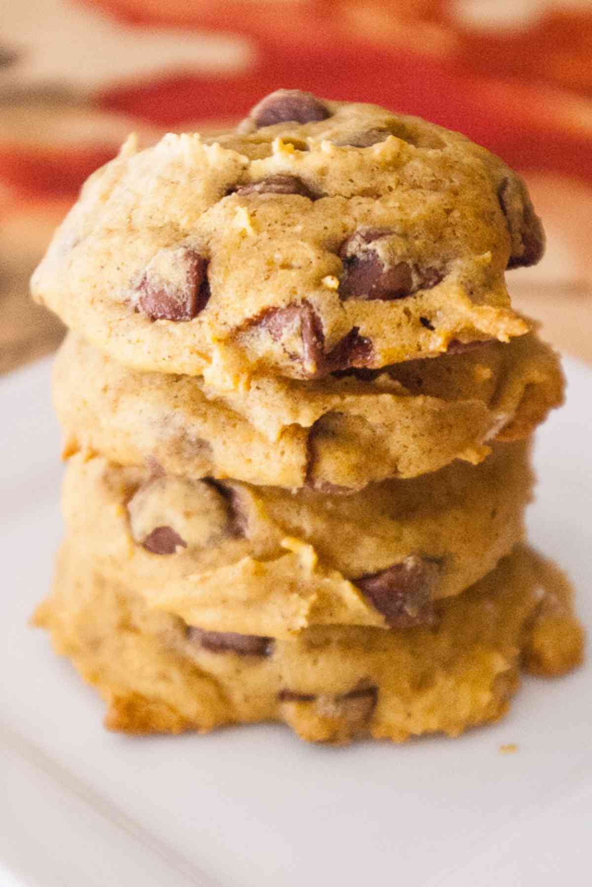 A stack of four soft pumpkin chocolate chip cookies.