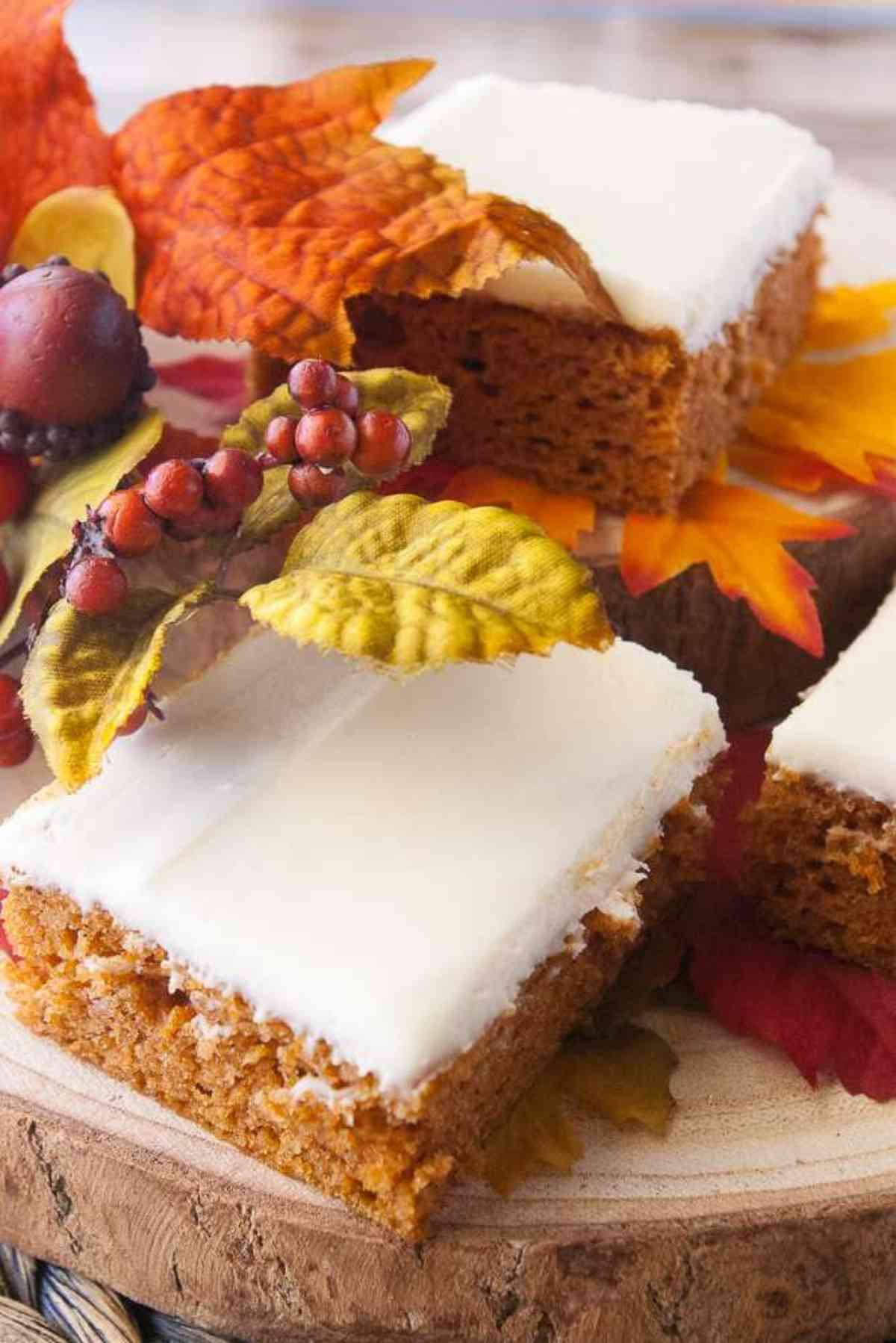 A slice of moist pumpkin cake frosted with cream cheese frosting.