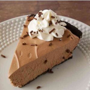 Slice of chocolate mousse pie garnished with whipped cream.