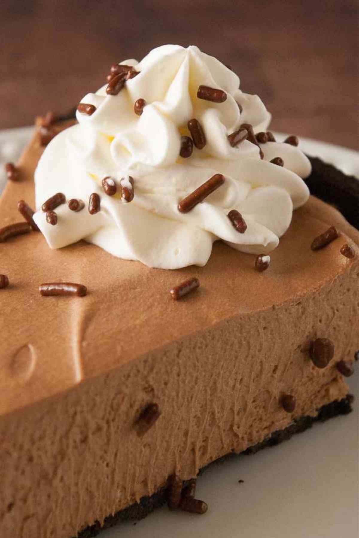 Slice of chocolate mousse pie topped with whipped cream.