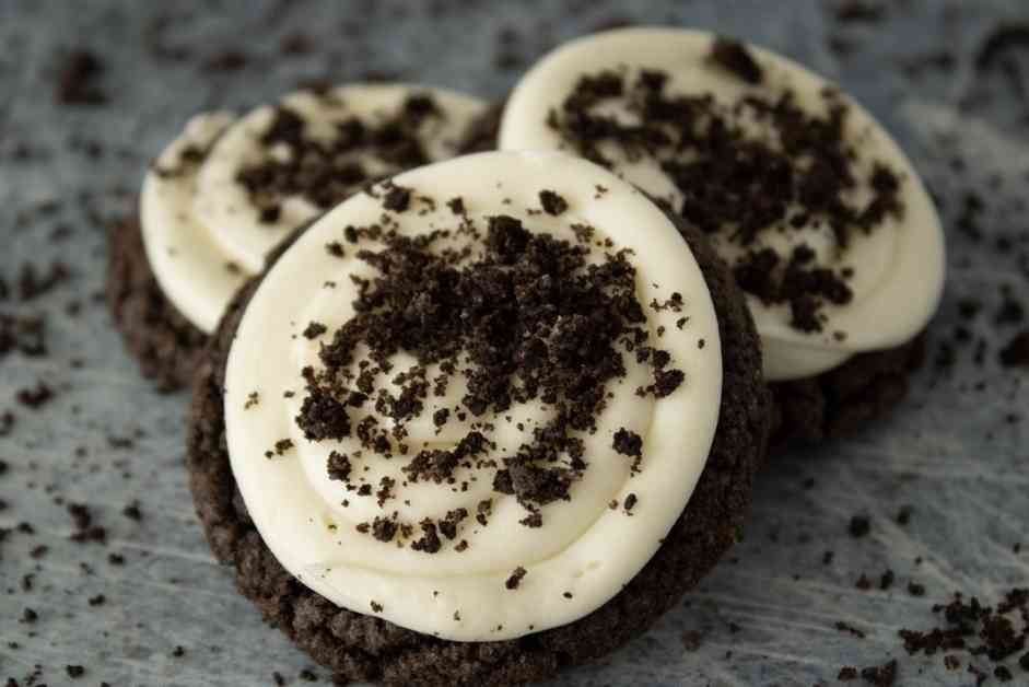 Three soft chocolate oreo cookies frosted with cream cheese frosting and sprinkled with oreo crumbs.