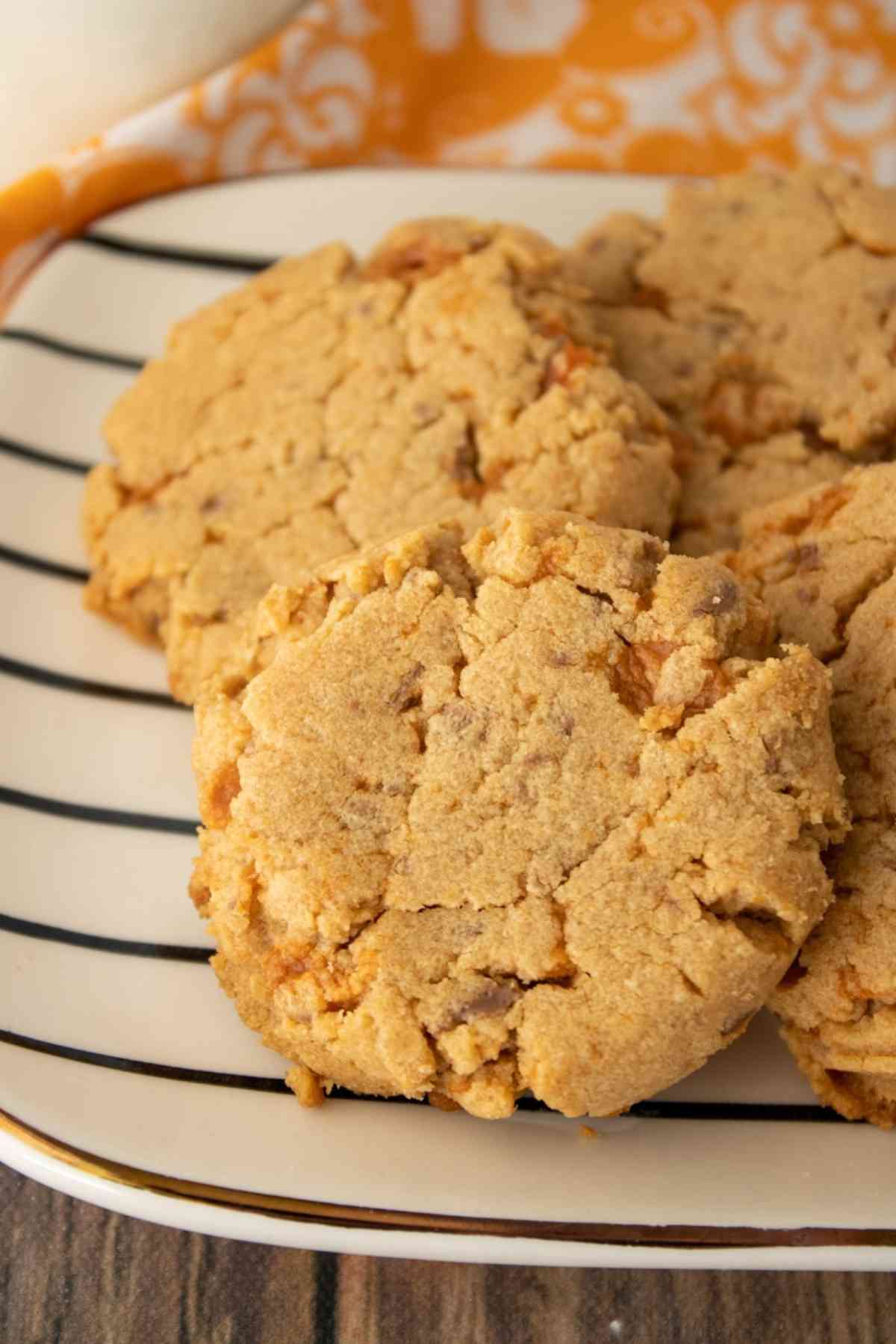 Butterfinger cookies on a striped plate.