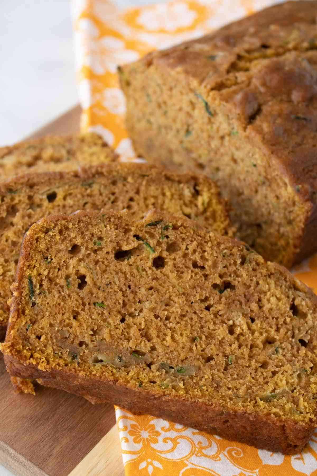 A loaf of pumpkin zucchini bread with a couple slices ready to eat!