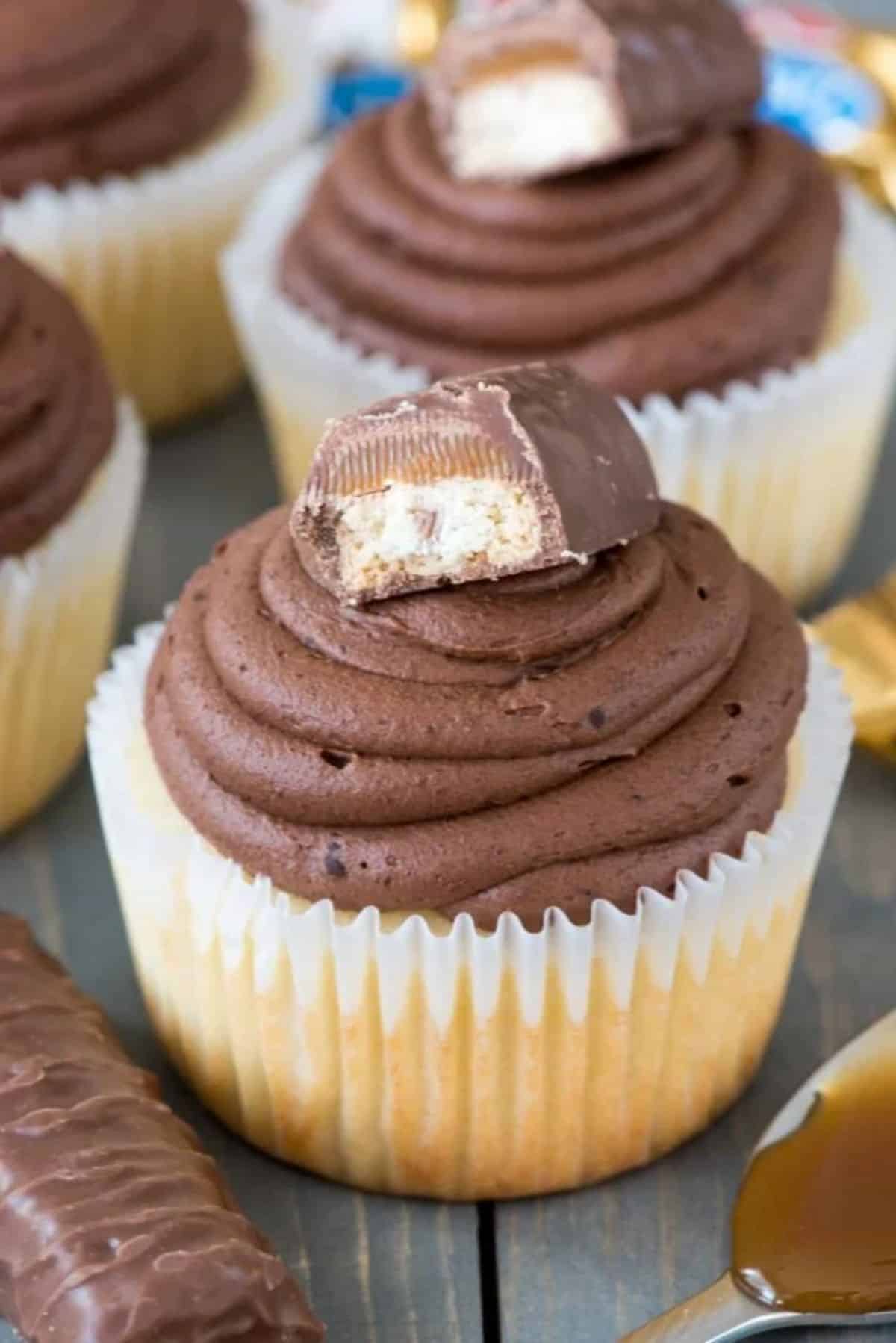 Twix Cupcakes on a wooden table.