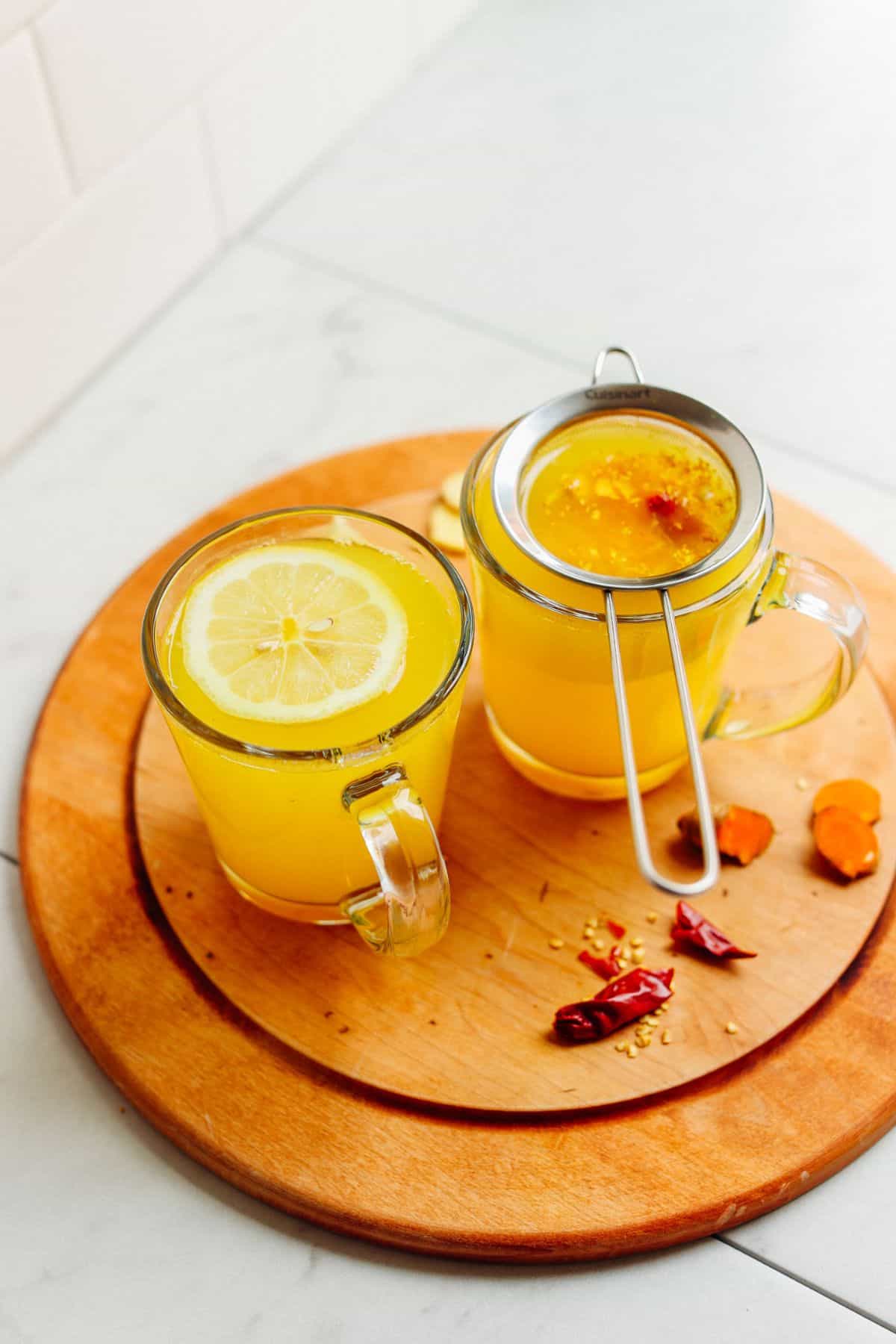 Turmeric Tonic in two glasses on a wooden tray.