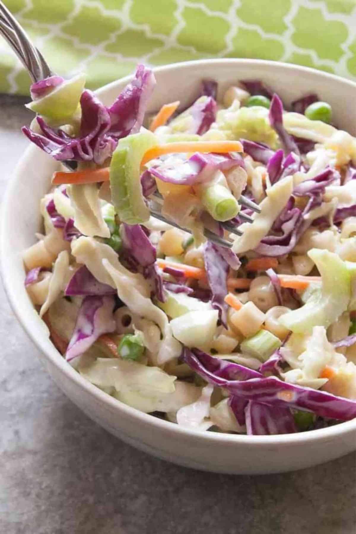 Tasty Macaroni Coleslaw Salad in a white bowl with a fork.
