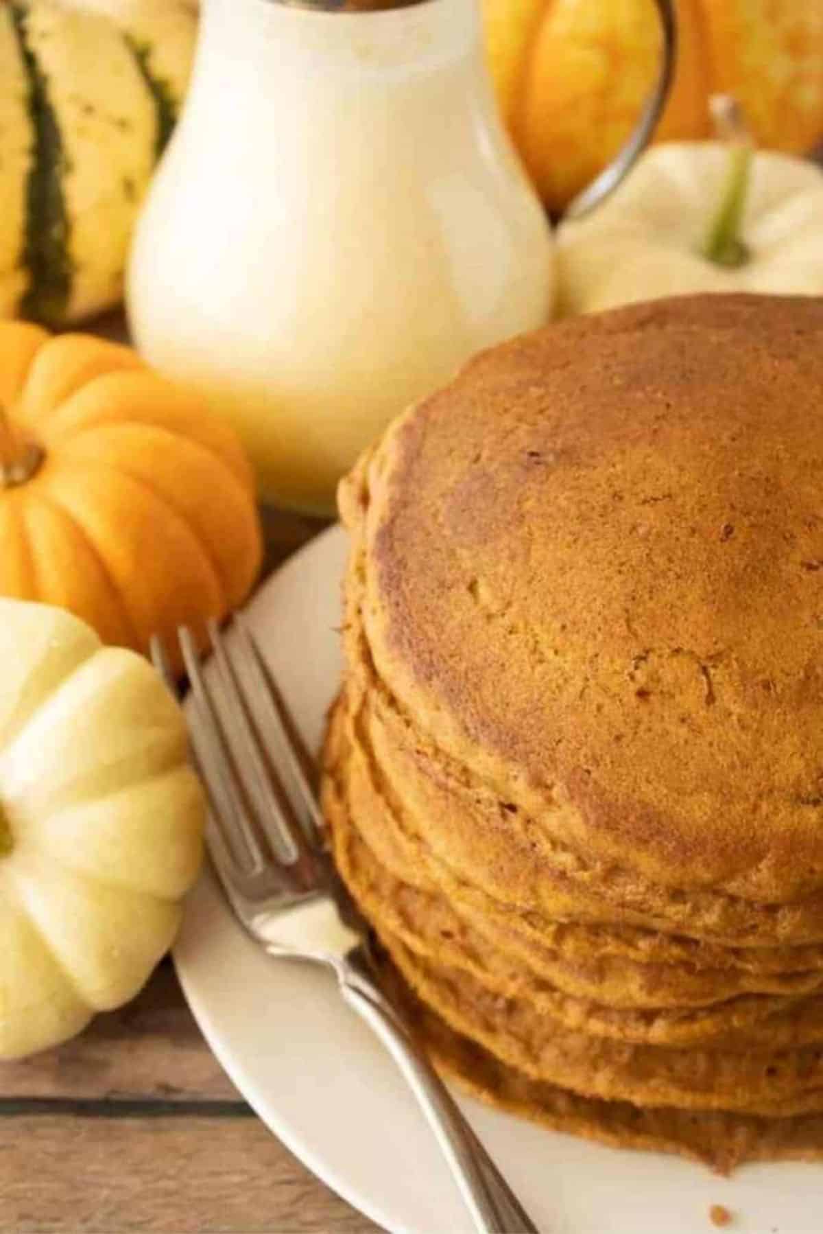 A pile of Pumpkin Pancakes on a white plate.