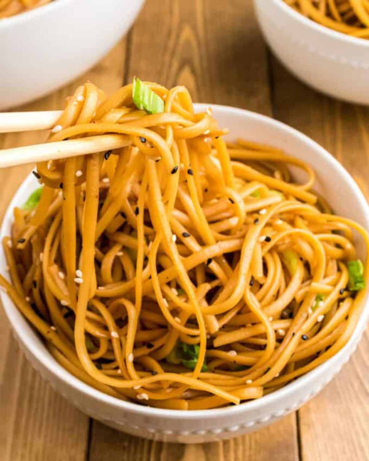 Delicious Simple Sesame Noodles in a white bowl picked with chopsticks.