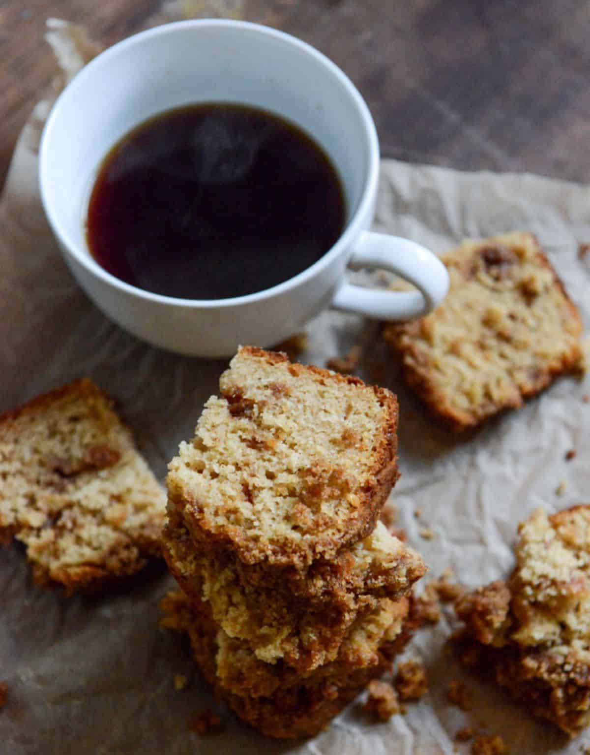 Pieces of Pomegranate Coffee Cake on a table with a cup of coffee.