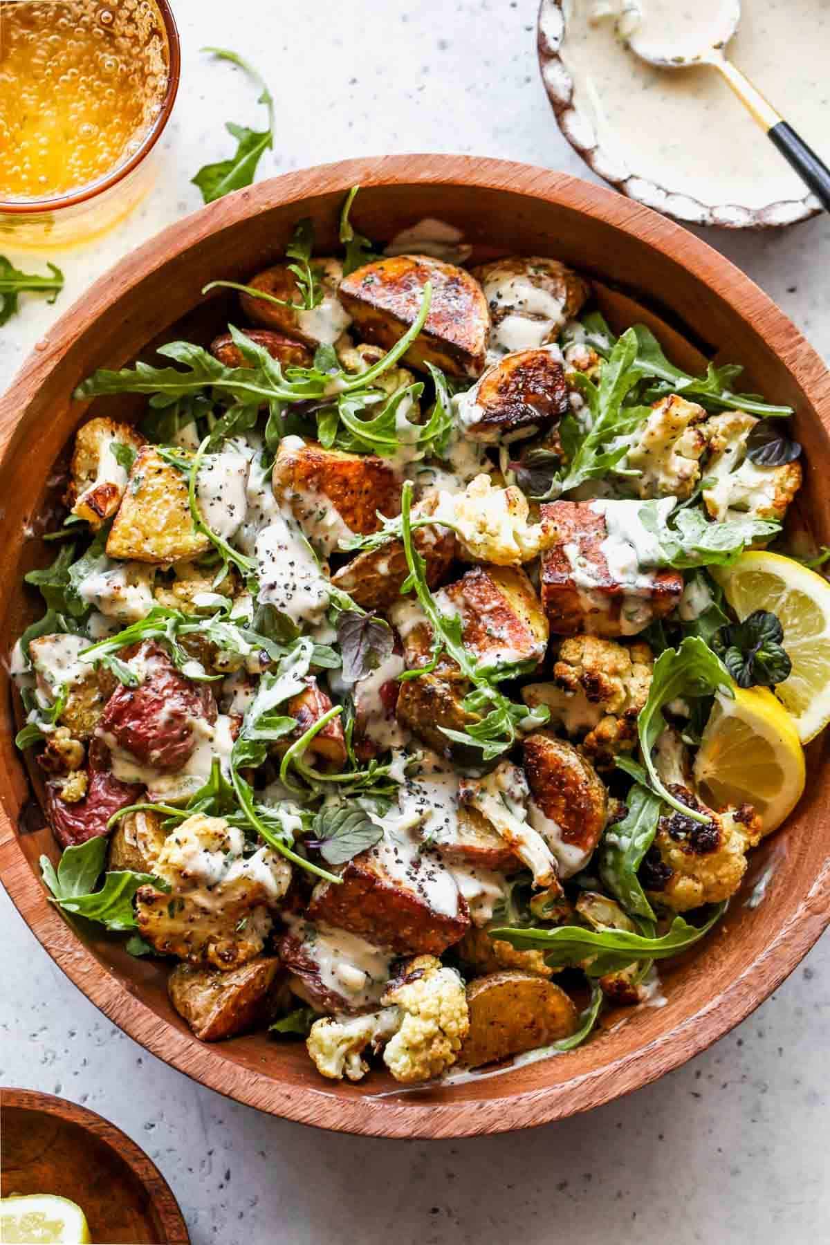 Roasted Cauliflower and Potato Salad With Tarragon Tahini in a wooden bowl.