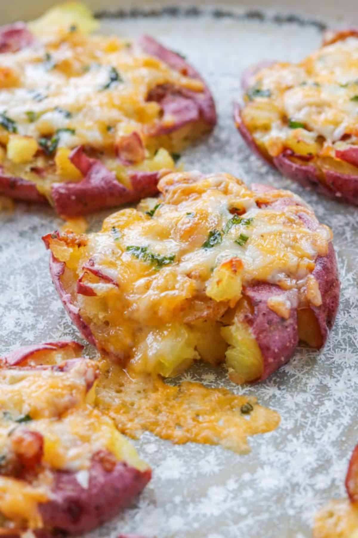 Smashed Potatoes With Cheese on a gray tray.