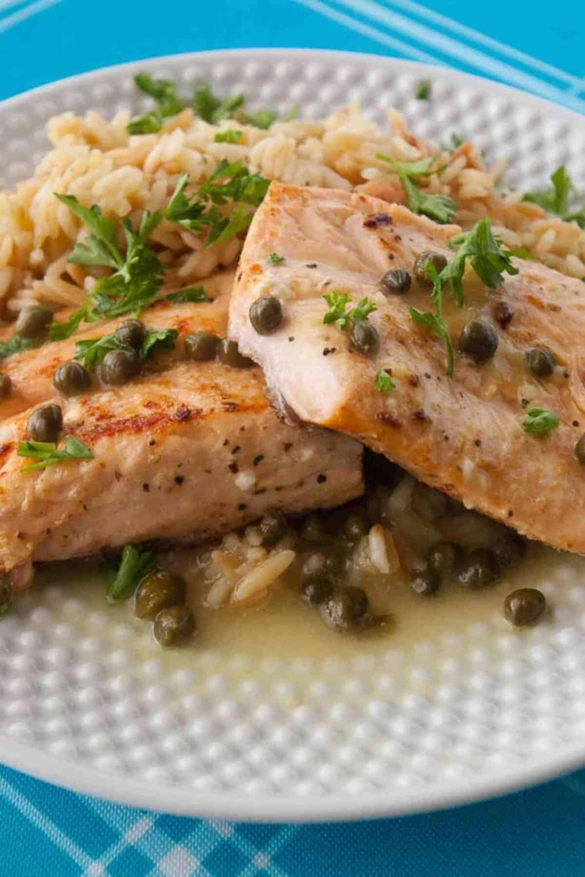 Salmon Piccata on a white plate.