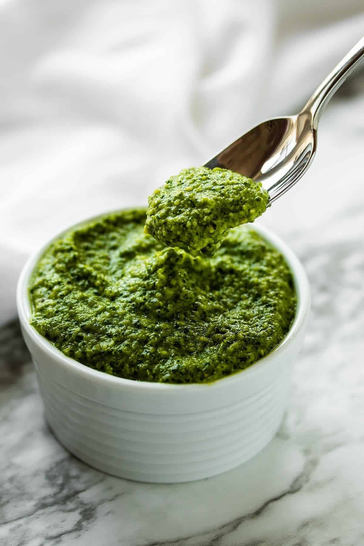 Easy Cashew Pesto in a small white bowl picked with a spoon.