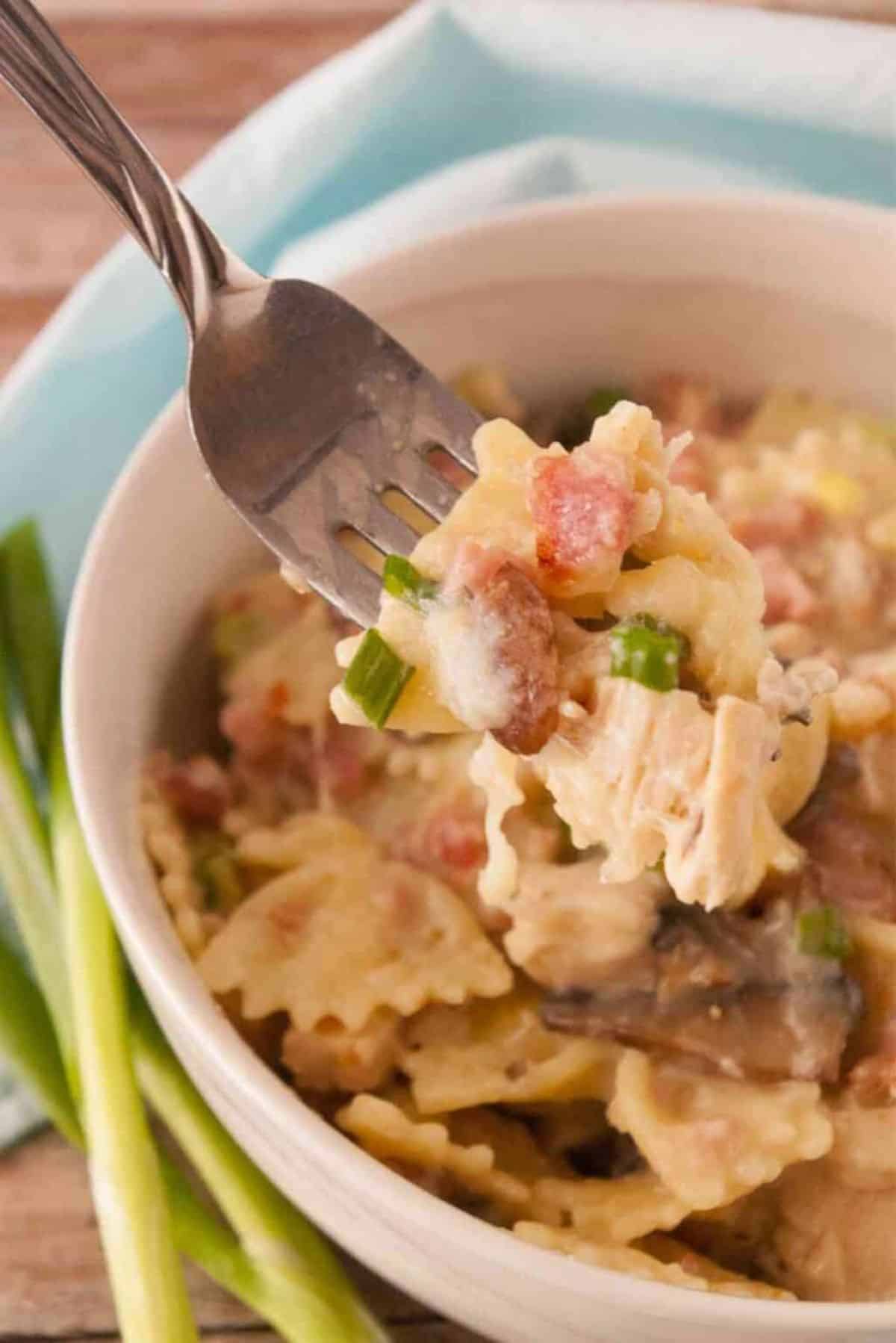 Scrumptious Chicken Cordon Blue on a fork and in a white bowl.