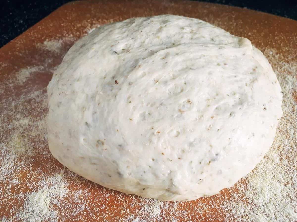 Oregano Garlic Pizza Dough on a wooden board.