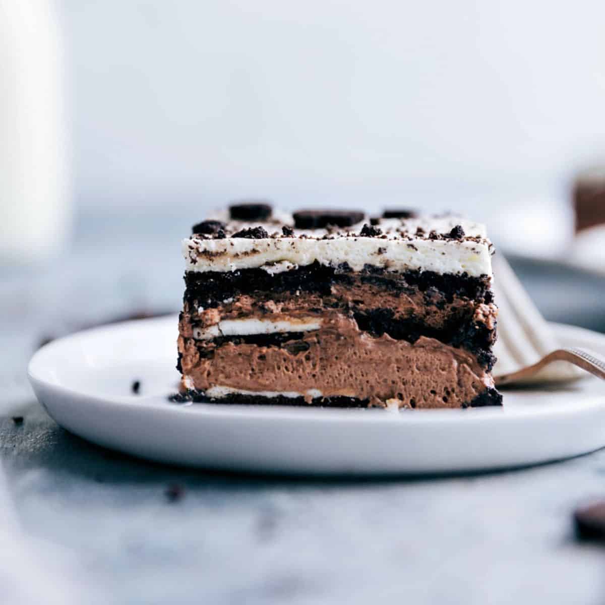 A piece of Icebox Oreo Cake on a white plate with a fork.