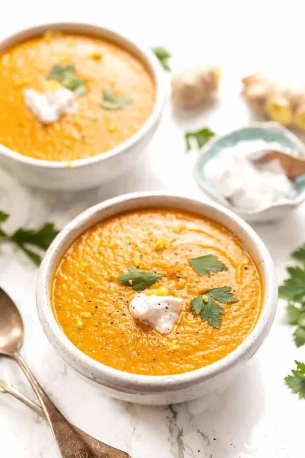Carrot Soup With Turmeric and Ginger in two white bowls.