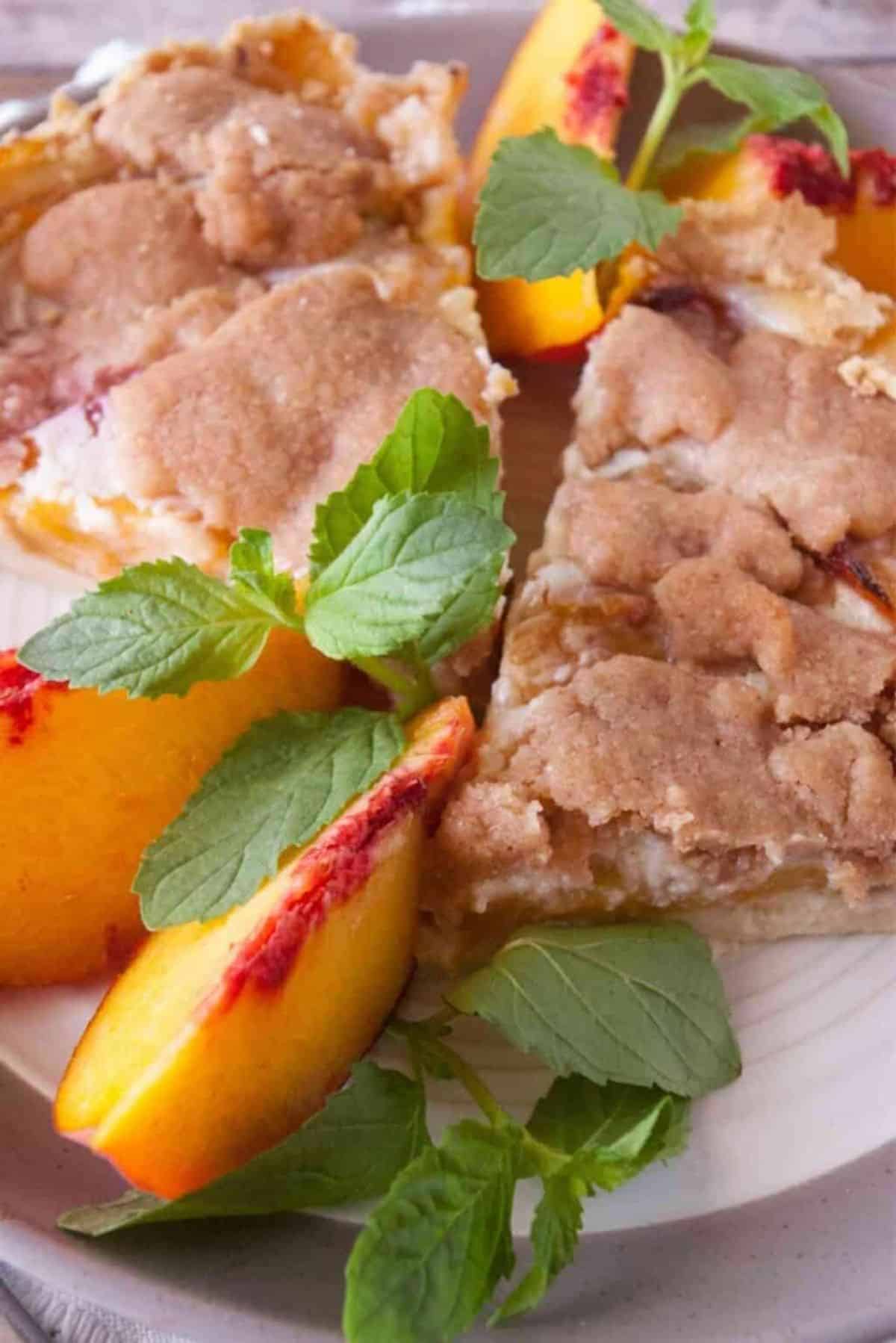 Two pieces of delicious Streusel Crumb Topped Peach Pie on a plate.