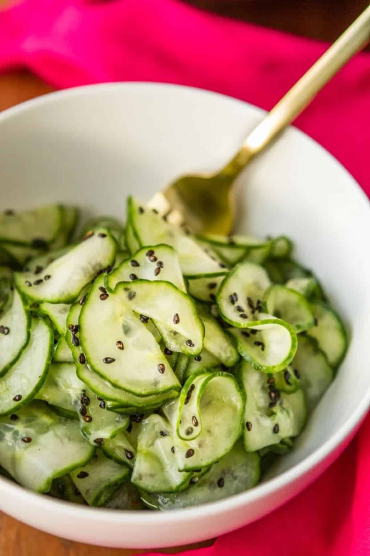Healthy 5-Ingredient Asian Cucumber Salad in a white bowl with a fork.