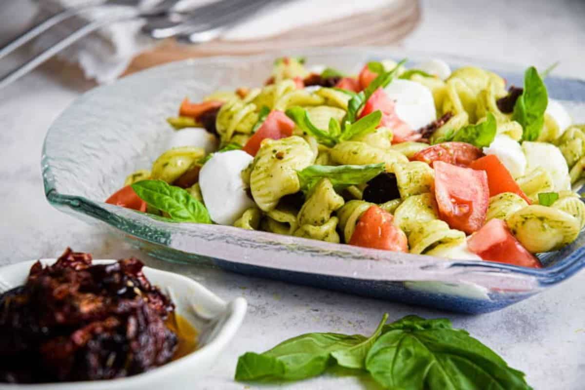 Healthy Caprese Pasta Salad on a glass tray.