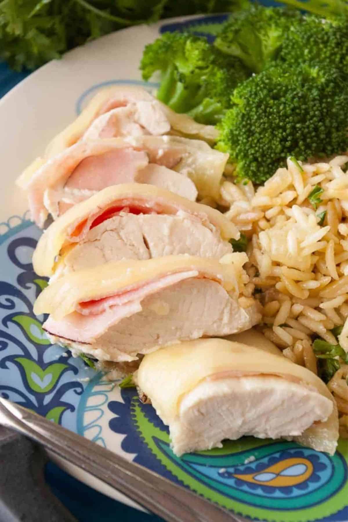 Chicken Cordon Bleu with rice and broccoli on a plate.