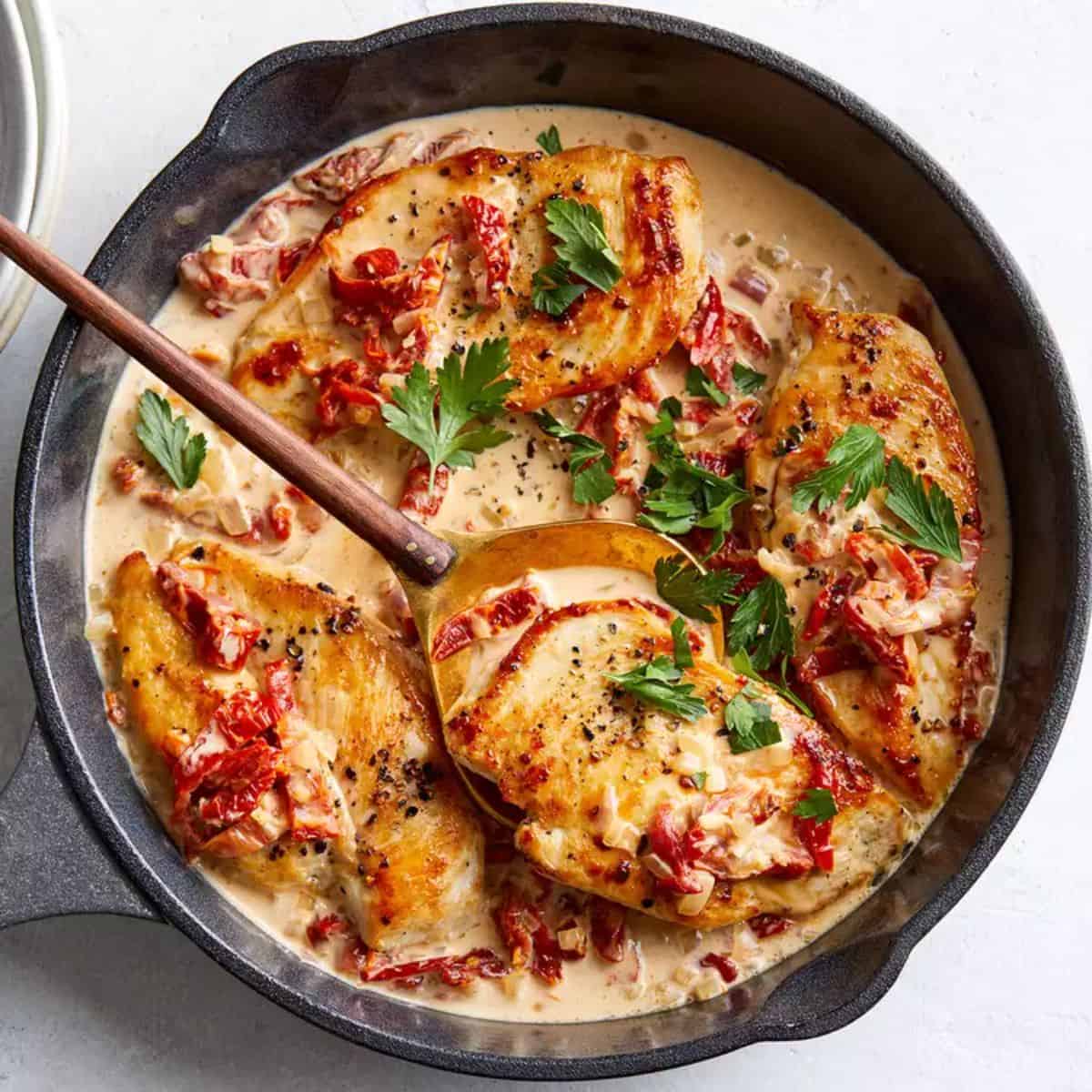 Chicken Cutlets with Sun-dried Tomato Cream Sauce in a black pot.