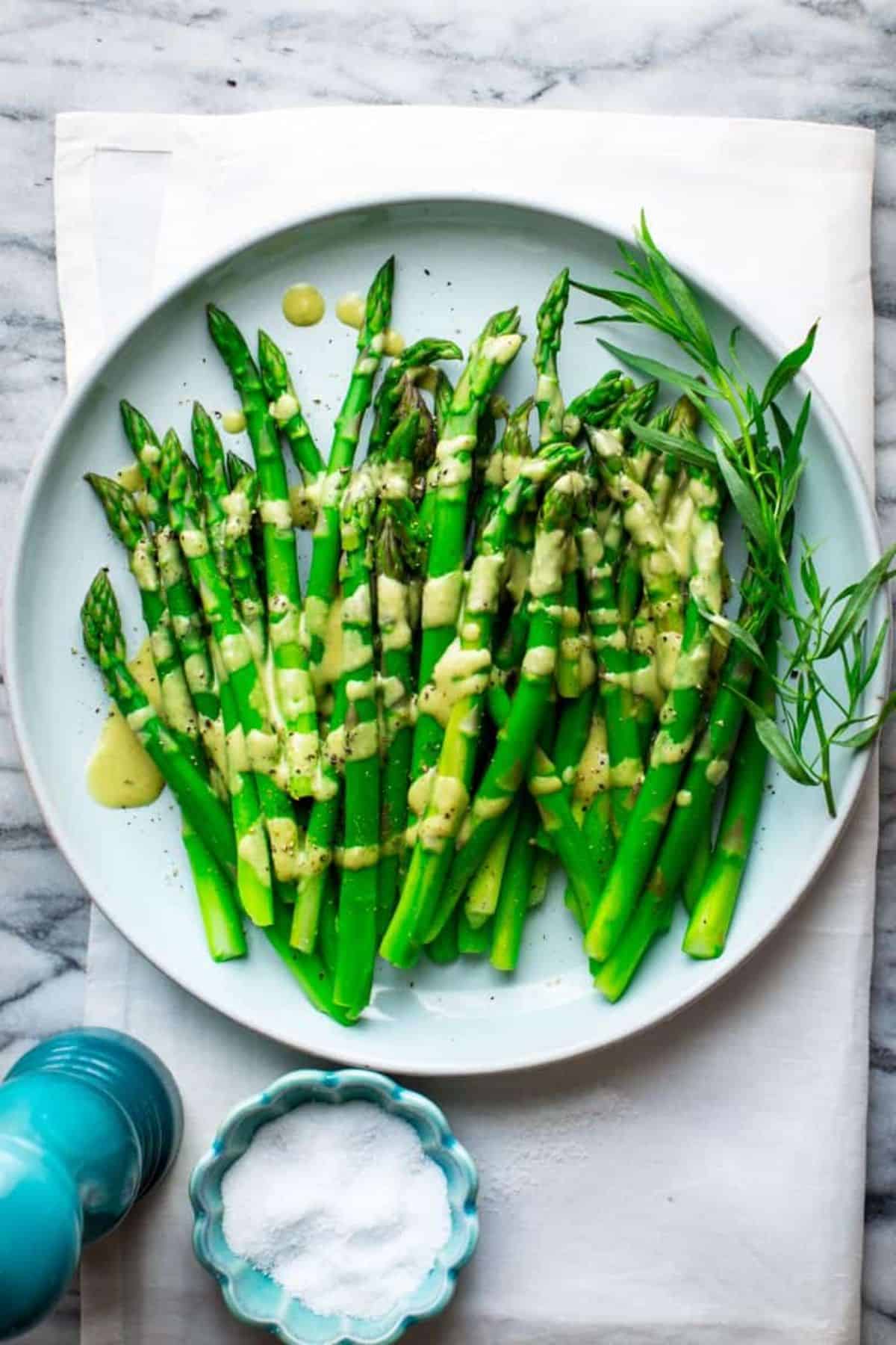 Healthy Asparagus With Tarragon Vinaigrette on a blue tray.