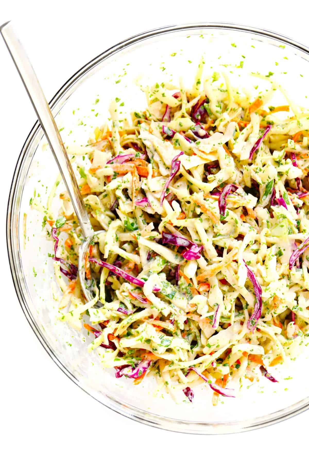 Cilantro Lime Slaw in a glass bowl with a spoon.