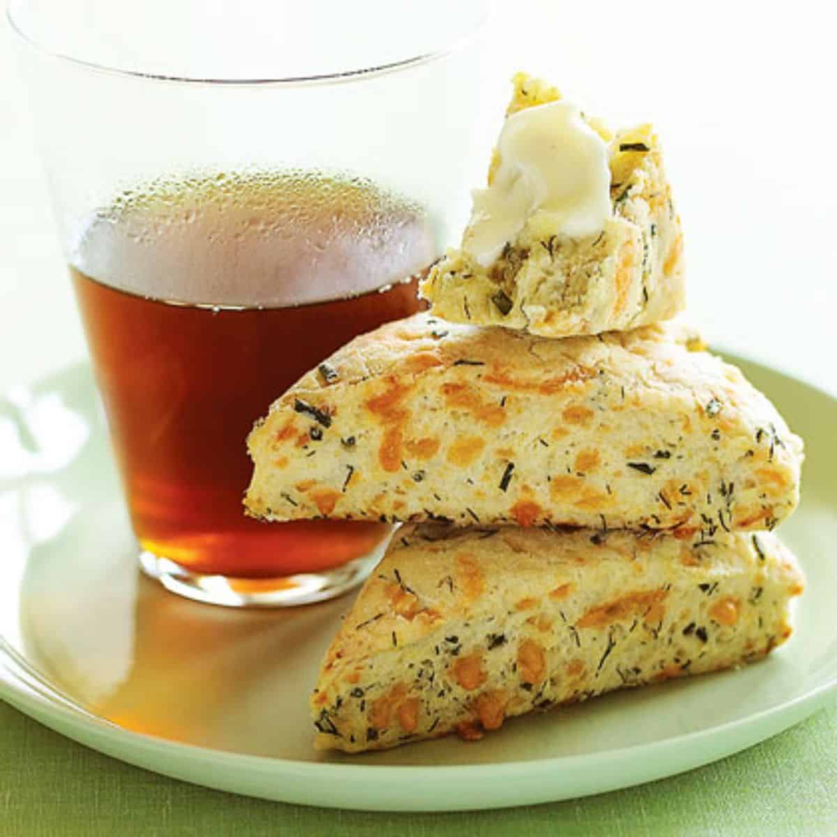 Dill and Cheddar Scones on a white tray with a glass of juice.