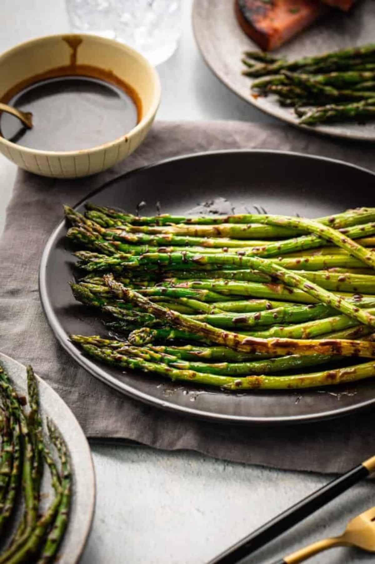 Healthy Balsamic Asparagus on a black plate.