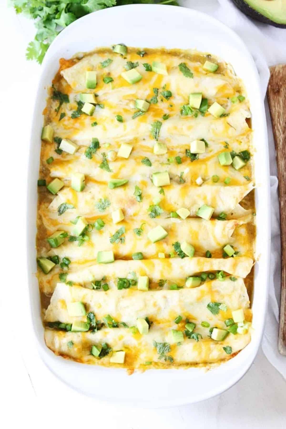 Creamy Spinach and Cheese Green Chile Enchiladas in a white casserole.