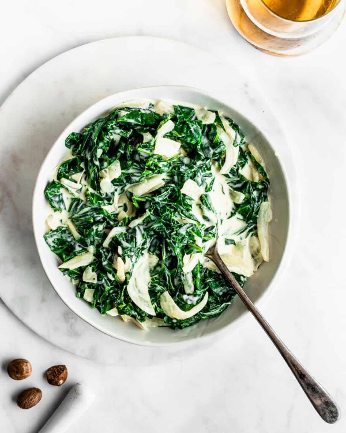 Healthy Creamed Collard Greens in a bowl with a spoon.