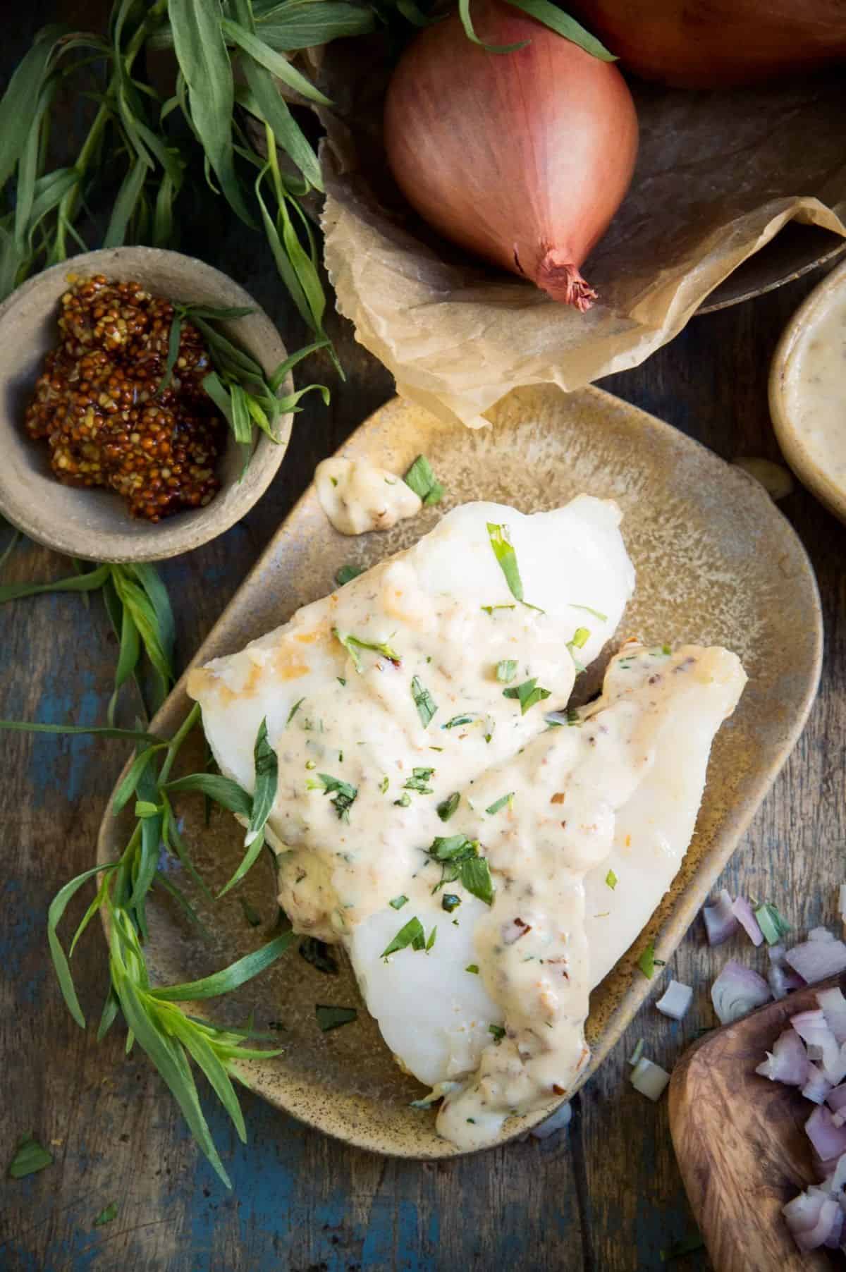 Sautéed Fish With Mustard Tarragon Cream Sauce on a gray tray.