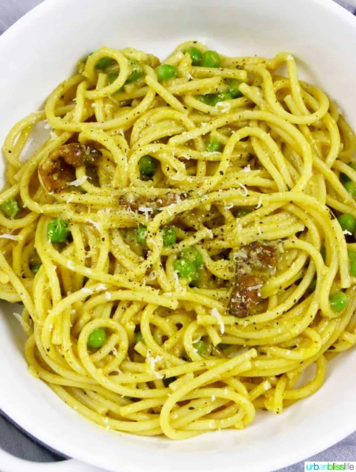 Bacon Turmeric Pasta With Peas on a white plate.
