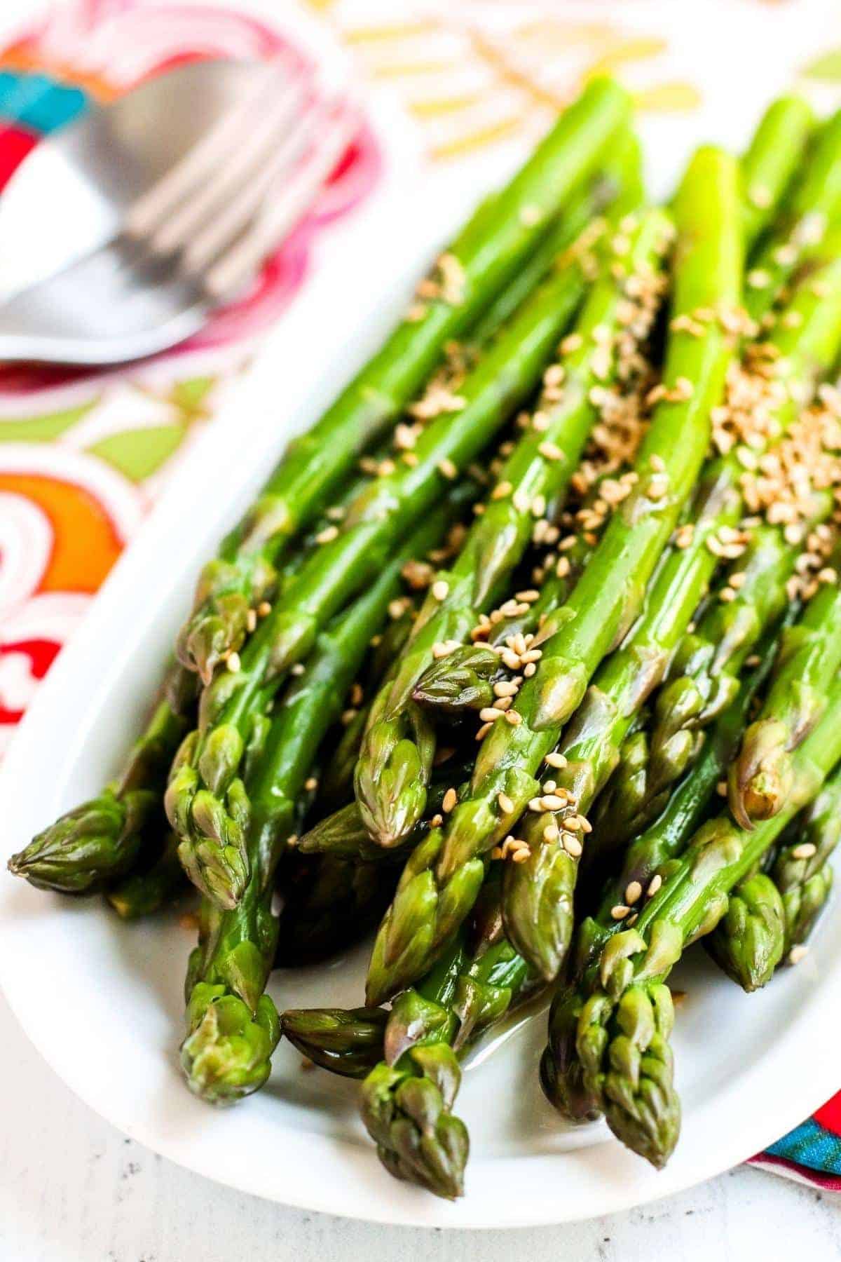 Healthy Cold Marinated Asparagus on a white tray.