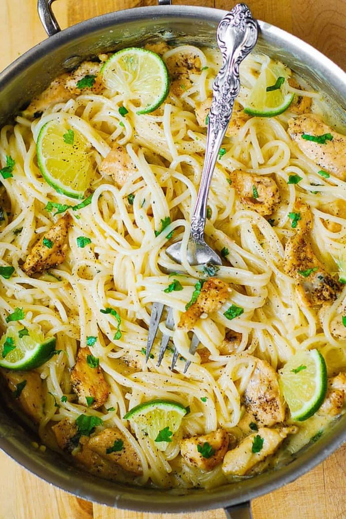 Chicken Pasta with Creamy Cilantro Lime Alfredo Sauce in a pot with a fork.